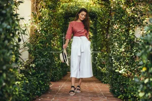 Attractive young tourist woman walking through a plant tunnel