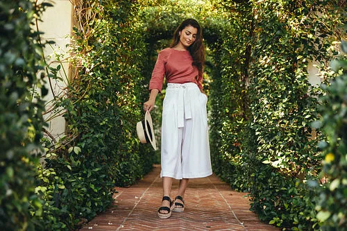 Attractive young tourist woman walking through a plant tunnel